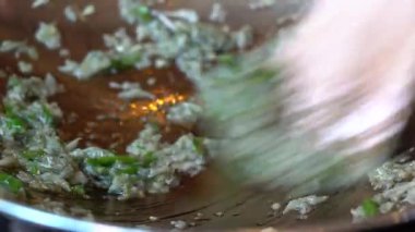 Tavada sebze yağında kızartılmış sarımsak ve yeşil biber. Elektrikli ocakta doğranmış sarımsak ve biberli kızartma tavası, yakın çekim. Endonezya