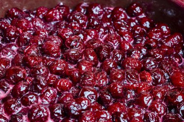 Delicious cherry jam in a saucepan, close up, top view. Summer preparation and preservation of berries for the winter, home cooking