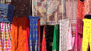 Udaipur, Rajasthan, Hindistan 'daki yerel sokak pazarında satılık renkli kıyafetlerin çeşitli ürünleri. Kapat.
