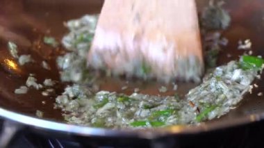 Tavada sebze yağında kızartılmış sarımsak ve yeşil biber. Elektrikli ocakta doğranmış sarımsak ve biberli kızartma tavası, yakın çekim. Endonezya