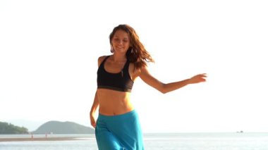 Genç güzel kız deniz kenarındaki tropikal kumsalda dinleniyor ve dans ediyor. Yaz kavramı. Tatil seyahati. Koh Phangan Adası, Tayland