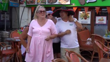 Bodrum, Türkiye - Eylül 09, 2019: Yetişkin insanlar bir sokak kafesinde dans ediyorlar. Türkiye turistler için cazip bir yer.