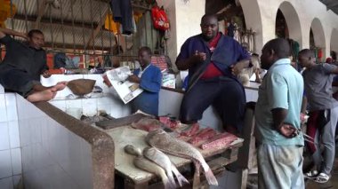 Zanzibar, Tanzanya - Kasım 03, 2019: Afrikalı erkekler Doğu Afrika 'daki Tanzanya' nın Zanzibar adasındaki yerel gıda pazarında taze deniz balığı hazırlayıp satıyorlar.