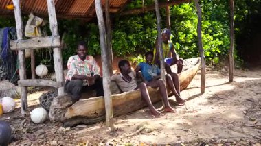 Zanzibar, Tanzanya - 16 Kasım 2019: Tanzanya, Doğu Afrika 'daki Zanzibar adasının sahilinde bilinmeyen Afrikalı erkekler tahta teknede oturuyorlar.