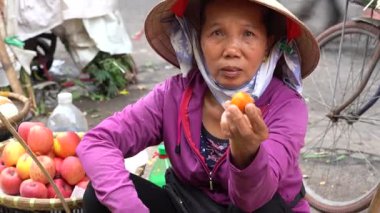 Hanoi, Vietnam - Mart 01, 2020: Kadınlar Hanoi, Vietnam 'daki eski bir kasabanın sokak gıda pazarında meyve ve sebze satıyorlar