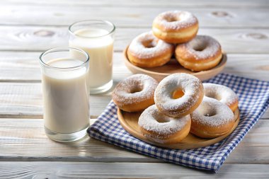 Tahta bir masada çörek ve süt.