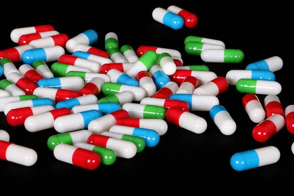 close up of a heap with colorful capsules in the dark studio