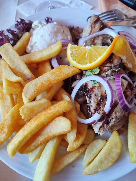 stock image Close up of plate with delicious food in restaurant. schnitzel with fries