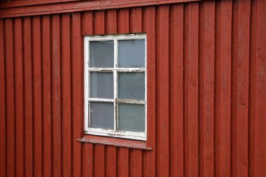 Küçük kırmızı ahşap bir evin eski beyaz penceresine yakın çekim
