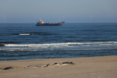 Tanker, mavi gökyüzüyle güzel bir havada kıyıda demirliyor.