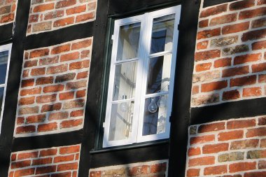 Penceresinde ampuller olan eski, yarı ahşap bir evin şirin küçük penceresine yakın plan.