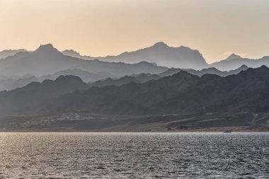 Mountains silhouettes and sea at sunset or sunrise