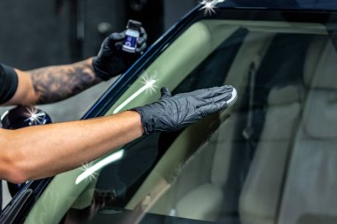 Worker applies nano protective coating to the car. Selective focus. Car detailing theme
