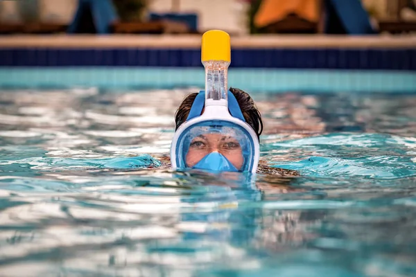 Woman swims in water in full face snorkeling mask