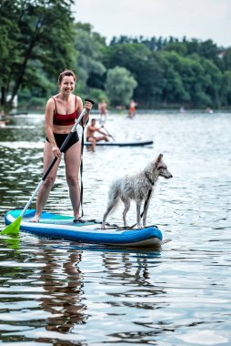 Köpeğiyle yemek masasında kürek çeken sportif bir kız. Yaz tatili teması