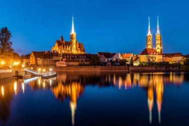 Polonya 'yı Tumski adası ve Vaftizci Yahya Katedrali' nin Odra nehrinden geçen köprüsü ile görüyor. Gece manzarası