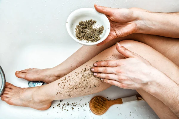 Woman scrubs the skin on her feet with mentol scrub. Spa and beauty theme