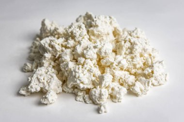 Beyaz arka planda bir yığın lezzetli süzme peynir.