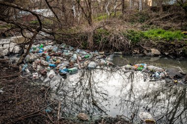 Nehirdeki farklı plastik çöpler, kirlilik ve çevre kavramı.