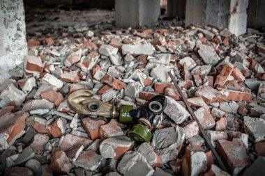 Harabelerde iki terk edilmiş gaz maskesi. Kırık tuğlalar