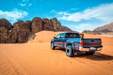 Wadi Rum Çölü 'nün kırmızı kum tepelerindeki off-road aracı. Ürdün