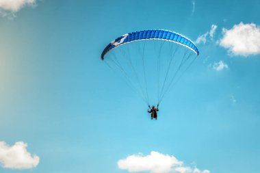 Mavi bulutsuz gökyüzünde uçan paraglider kanadı. Spor ve eğlence teması