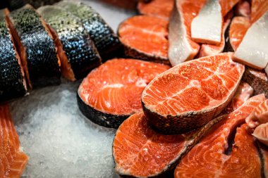 Çiğ dilimlenmiş, pişmemiş somon balığı, kırmızı balık, süpermarkette tezgahın üzerinde yatıyor. Sanayi teması