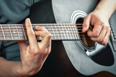 Siyah akustik gitar çalan adam. İnsan ellerinde akustik gitar
