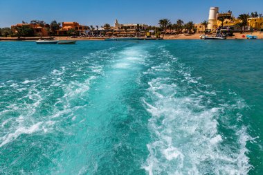 Tekne, yaz tatilinde mavi su yüzeyinde iz bırakmış.