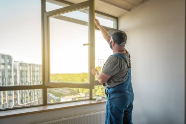 İnşaat işçileri yeni pencere döşüyorlar.