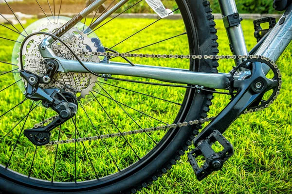 Bicycle gears, chain, disc brake and rear derailleur on green grass