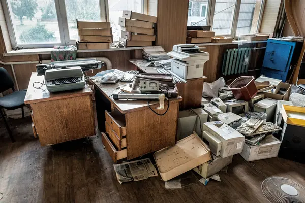 不同的旧办公室垃圾在废弃的房间里 图库图片