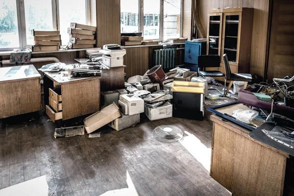 不同的旧办公室垃圾在废弃的房间里 免版税图库图片