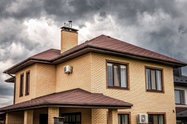 Yeni ev çatılarının üzerinde kara fırtına bulutları