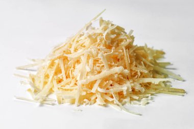 Beyaz arka planda bir yığın lezzetli rendelenmiş parmesan peyniri.