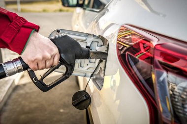 Car fueling at gas station. Refuel fill up with petrol gasoline. Petrol pump filling fuel nozzle in fuel tank of car at gas station. Transportation theme