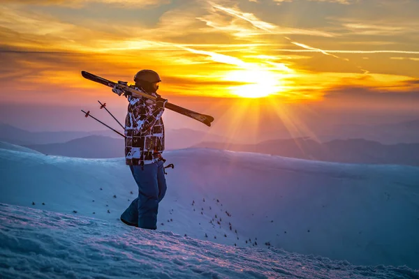 Skier Silhouette with ski at sunset or sunrise in winter mountains