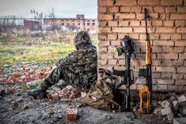 Siber punk, post-kaliptik dünya, kapüşonlu adam, keskin nişancı tüfeği, şehir enkazında gaz maskesi