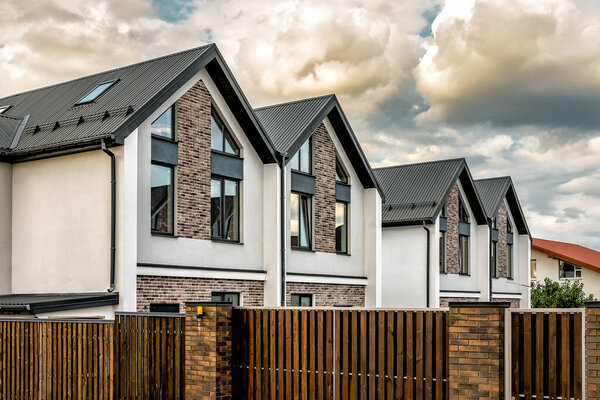Готовые новые таунхаусы, дом-близнец под облачным небом. Промышленная тема