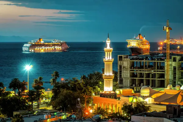 Pemandangan Malam Teluk Dengan Dua Kapal Pesiar Dan Menara Masjid Stok Foto