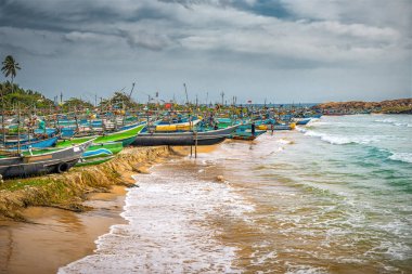 Tropik plaja demirlemiş renkli geleneksel ahşap balıkçı tekneleri. Seyahat ve tatil teması