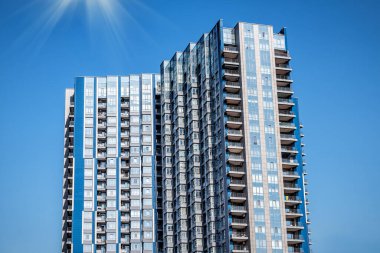 Mavi gökyüzü arka planında mavi modern apartman binaları veya gökdelenler