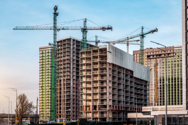 Şantiyedeki Crane gün batımında yeni gökdelenler inşa ediyor. Sanayi teması