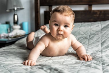 Yatakta yatan sevimli erkek bebek portresi.