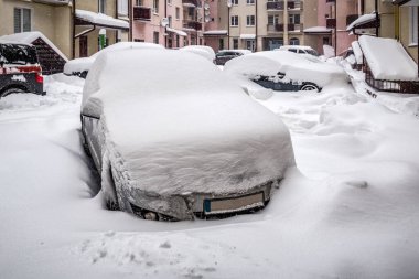 Kış boyunca kar fırtınasından sonra neredeyse tamamen kar altında kalmış bir araba.