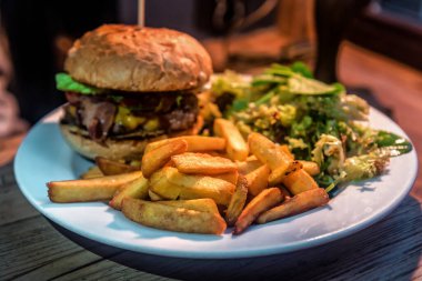 Biftek köfteli lezzetli burger, domates soslu salata ve patates kızartması. Yiyecek ve içecek teması