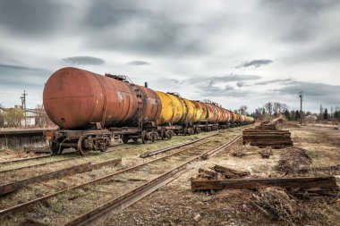 Terk edilmiş demiryollarındaki eski paslı petrol tankerleri. Endüstriyel ulaşım teması