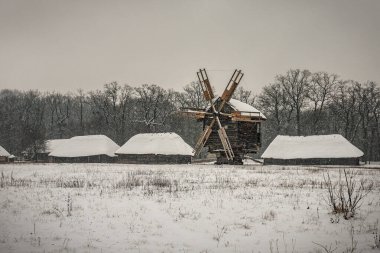 Terk edilmiş eski köyde eski ahşap yel değirmeni Kış karları, güzel manzara
