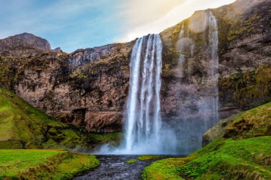 Gün batımında İzlanda 'daki bir uçurumdan güzel bir şelale düşüyor.