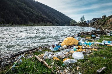 Dağlardaki nehir kıyısında farklı plastik çöpler. Çevre kirliliği teması